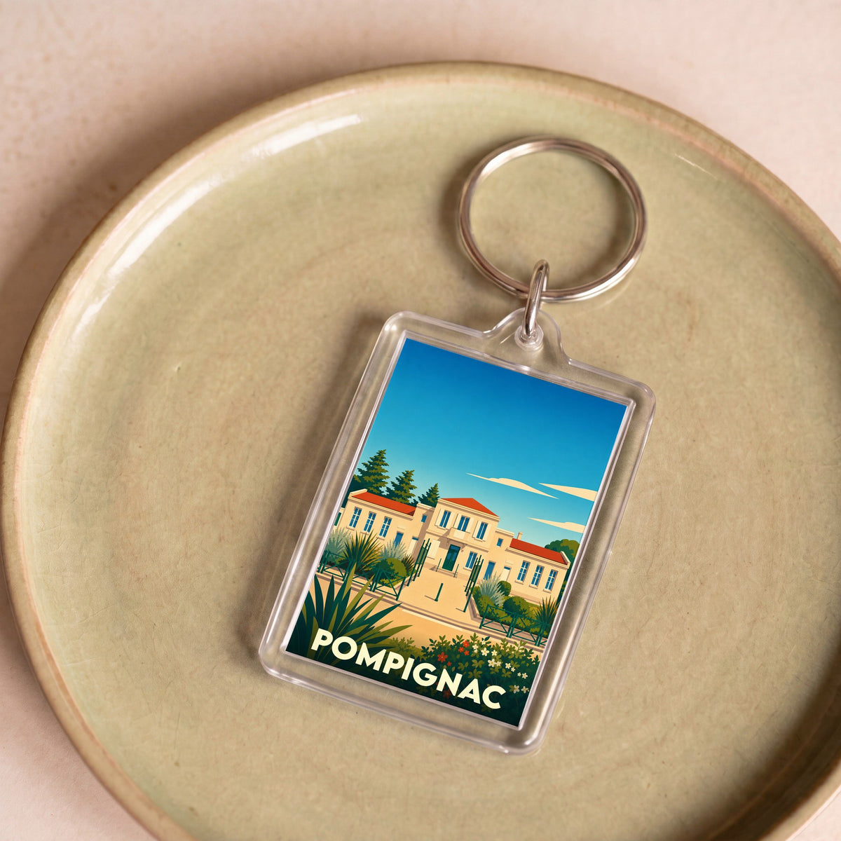Porte-clés souvenir de la ville de Pompignac avec une illustration stylisée.