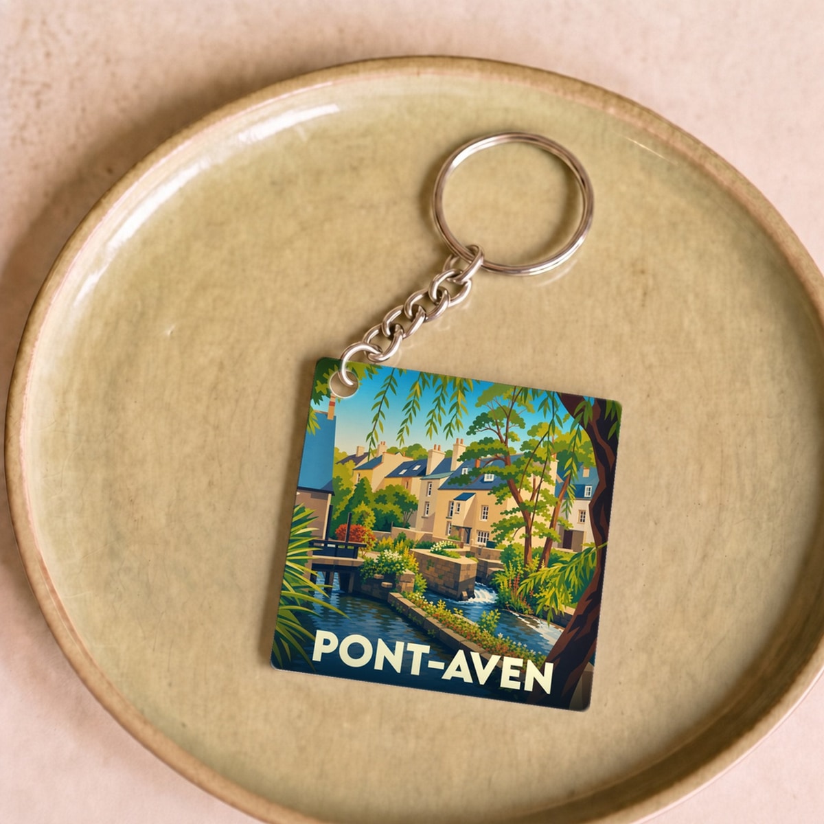 Porte-clés souvenir de la ville de Pont-Aven avec une illustration colorée et stylisée de ses canaux.