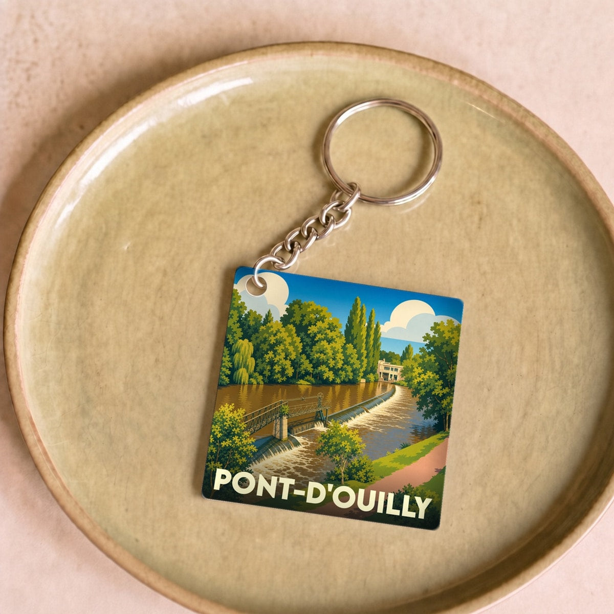 Porte-clés souvenir de la ville de Pont-d'Ouilly avec une illustration stylisée.