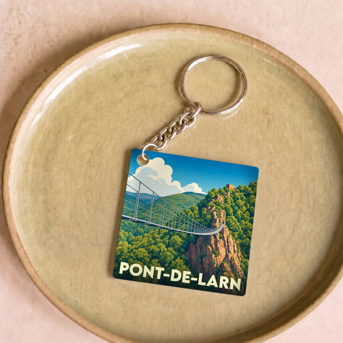 Porte-clés souvenir de la ville de Pont-de-Larn avec une illustration stylisée d'une passerelle suspendue.