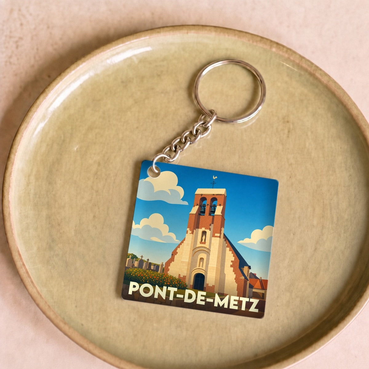 Porte-clés souvenir de la ville de Pont-de-Metz avec une illustration stylisée de son église.