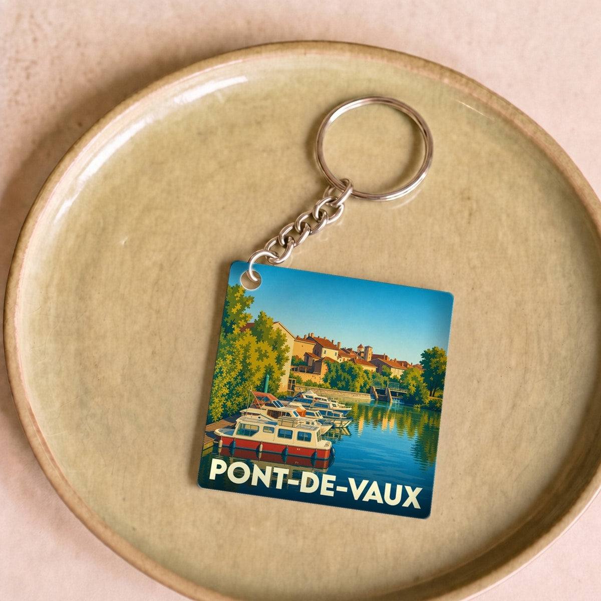 Porte-clés souvenir de la ville de Pont-de-Vaux avec une illustration stylisée d'un port de plaisance.