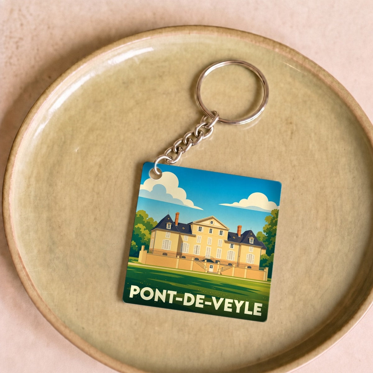 Porte-clés souvenir de la ville de Pont-de-Veyle avec une illustration stylisée de son château.