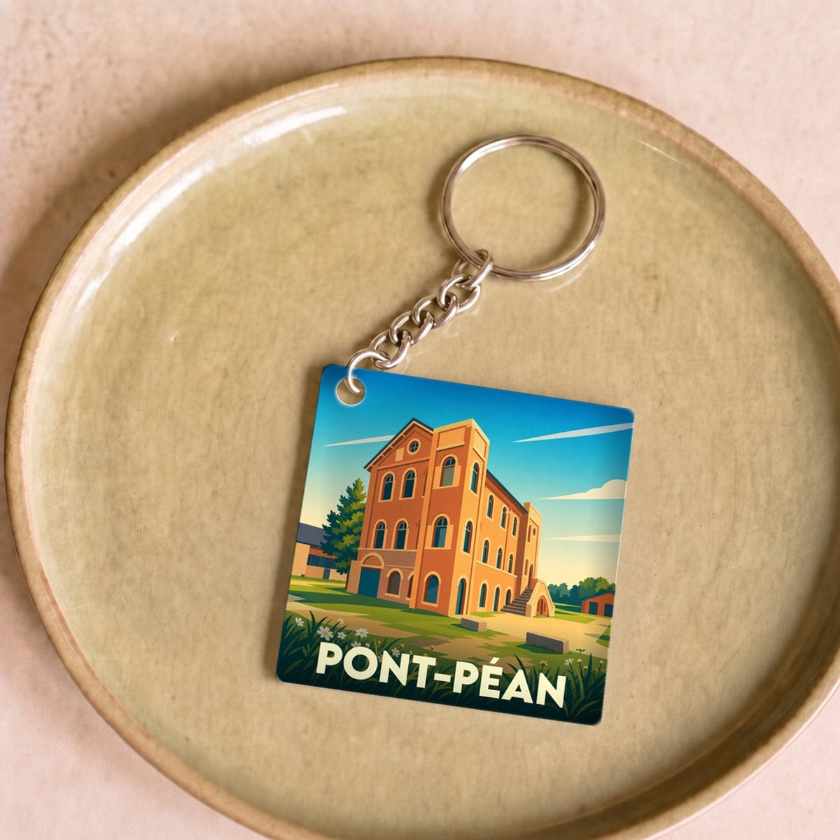 Porte-clés souvenir de la ville de Pont-Péan avec une illustration stylisée de son patrimoine architectural.