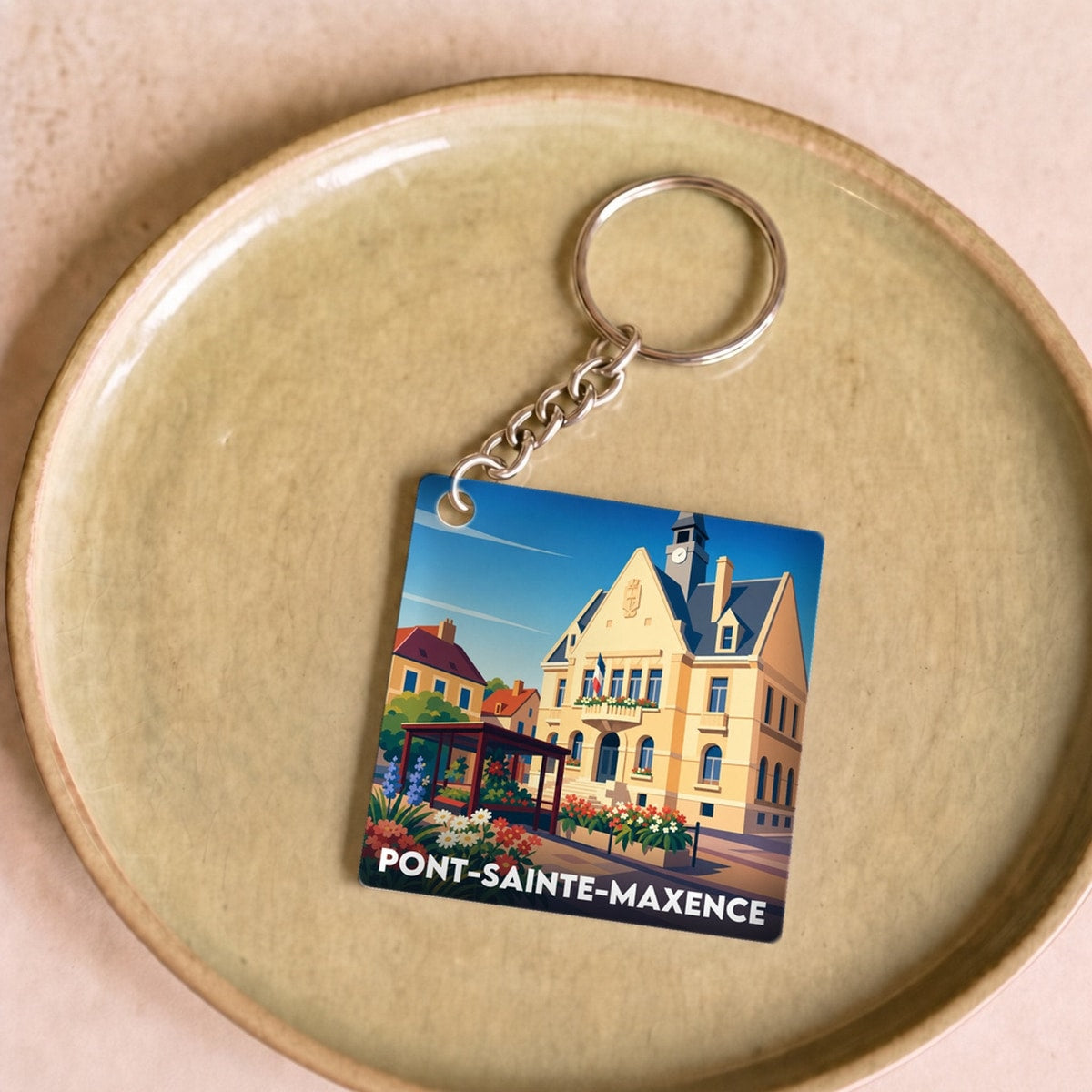 Porte-clés souvenir de la ville de Pont-Sainte-Maxence avec une illustration stylisée.