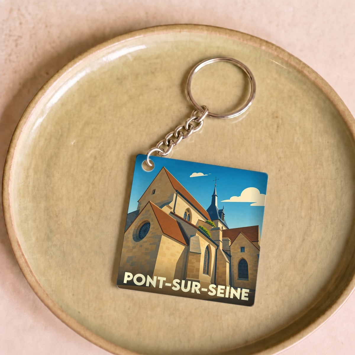 Porte-clés souvenir de la ville de Pont-sur-Seine avec une illustration stylisée de son église.