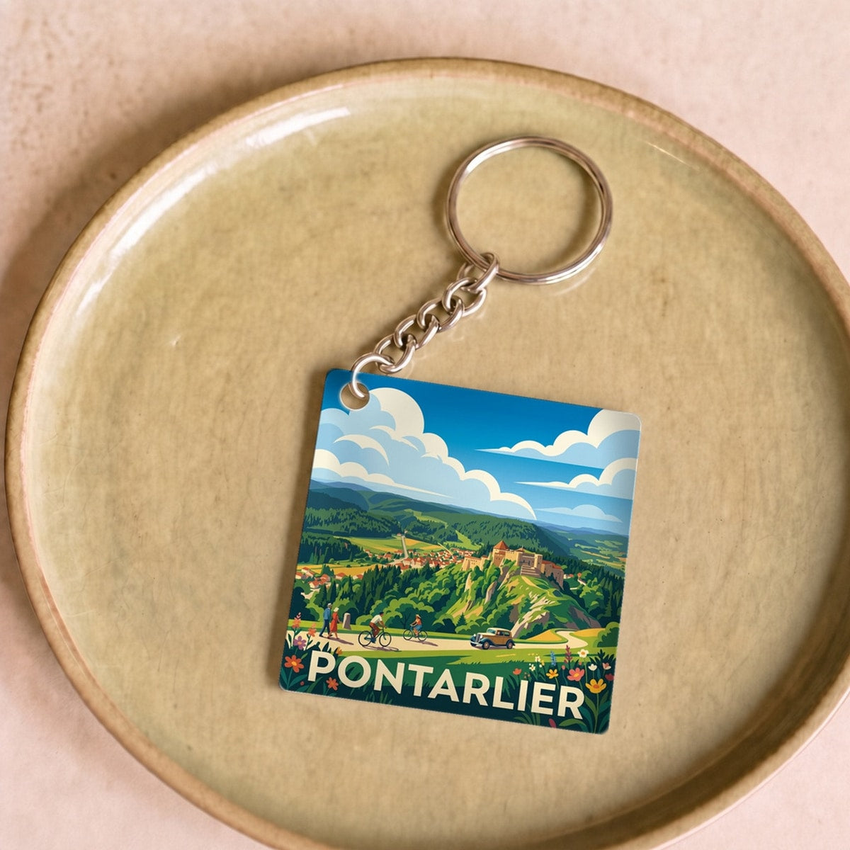 Porte-clés souvenir de la ville de Pontarlier avec une illustration de paysage stylisée.