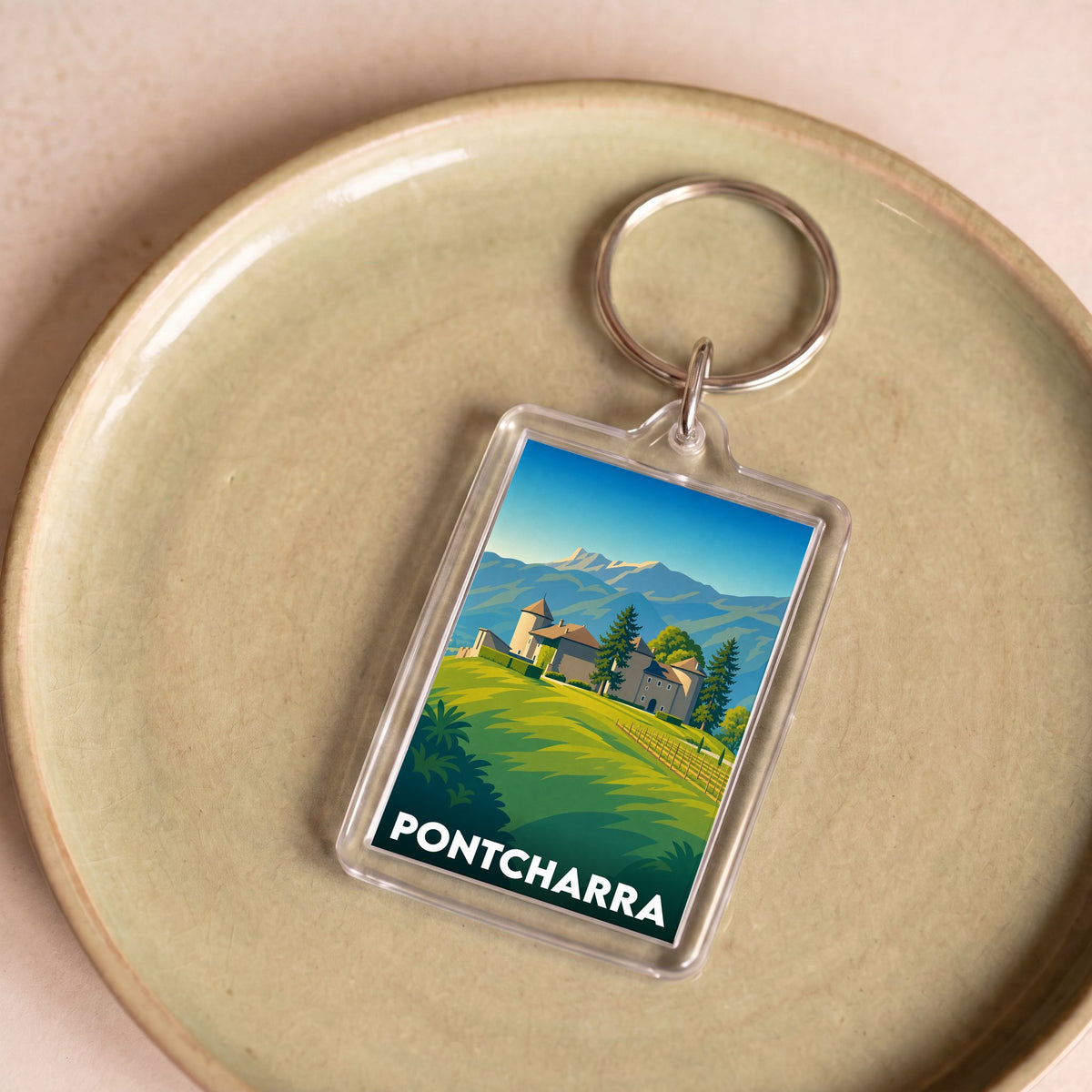 Porte-clés souvenir de la ville de Pontcharra avec une illustration stylisée d'un paysage montagneux.