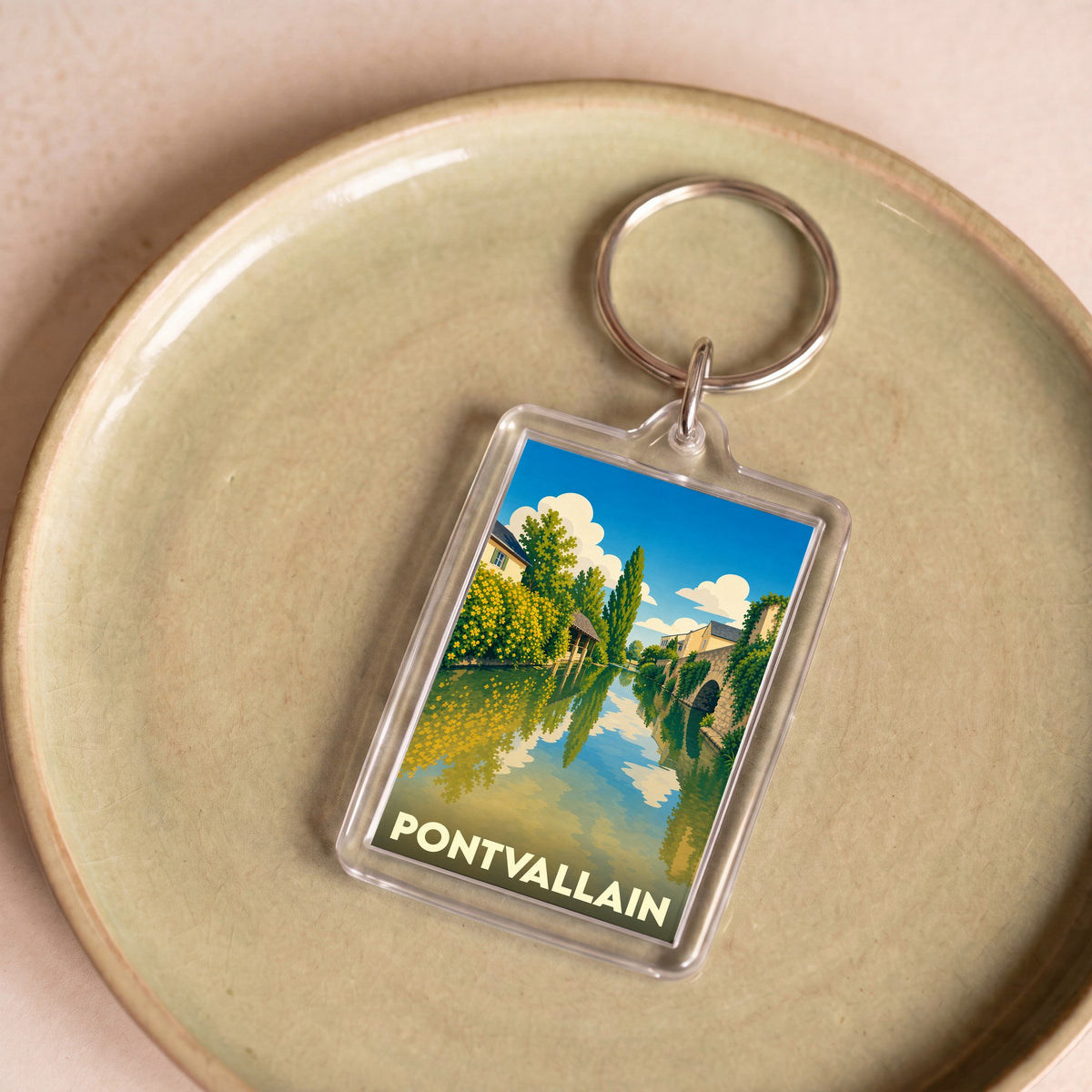 Porte-clés souvenir de la ville de Pontvallain avec une illustration stylisée d'un paysage fluvial.