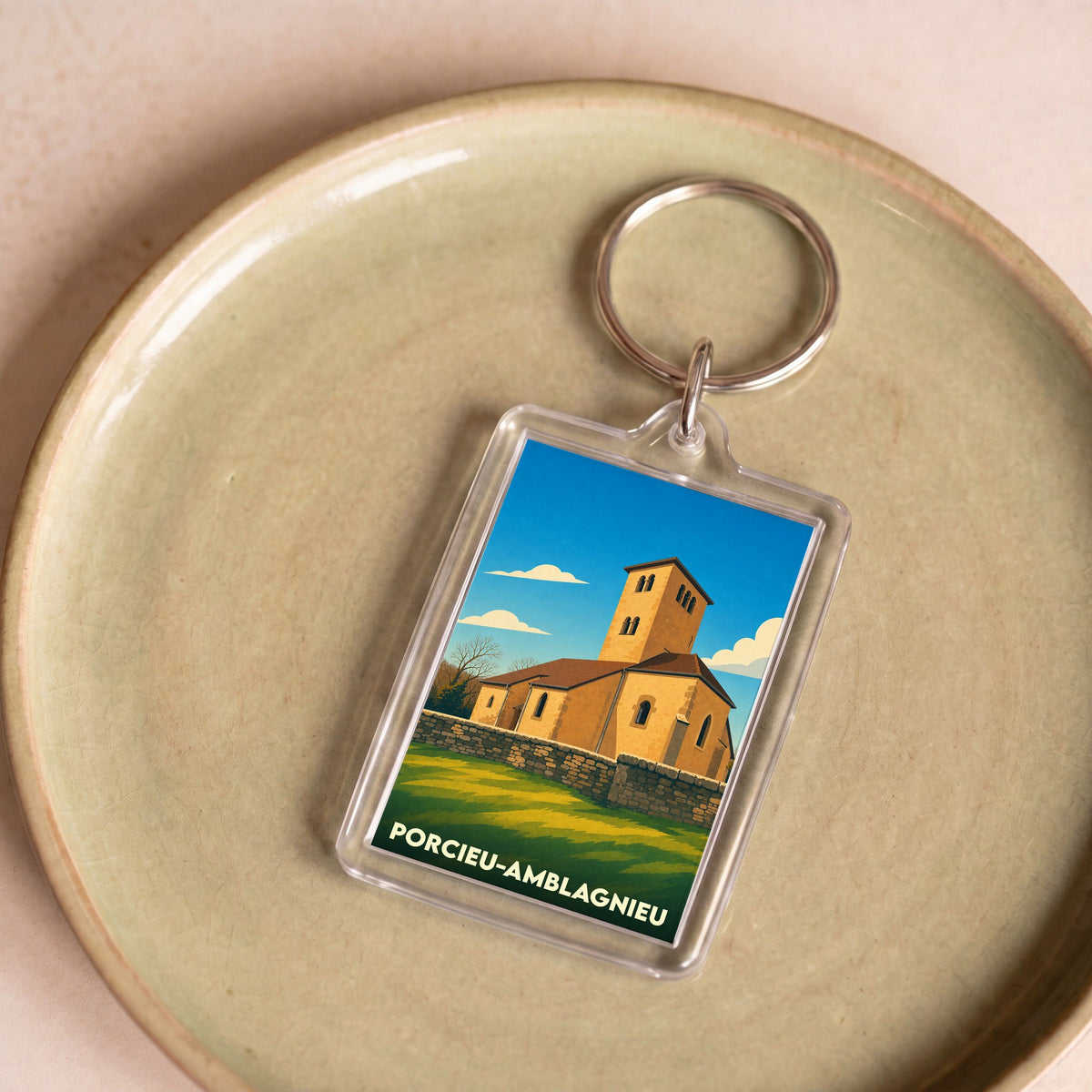 Porte-clés souvenir de la ville de Porcieu-Amblagnieu avec une illustration stylisée de son église.