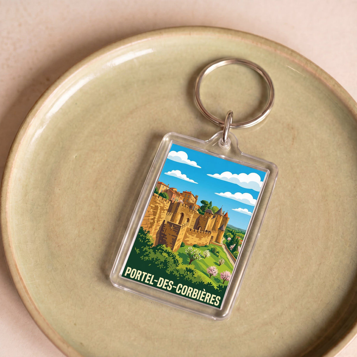 Porte-clés souvenir de la ville de Portel-des-Corbières avec une illustration stylisée.