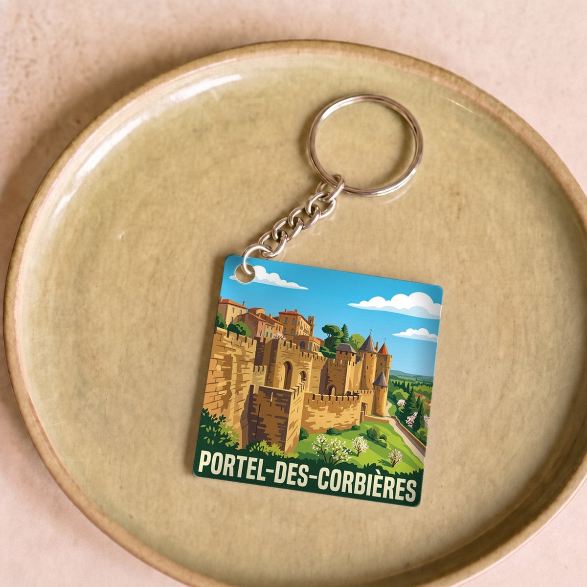 Porte-clés souvenir de la ville de Portel-des-Corbières avec une illustration stylisée.