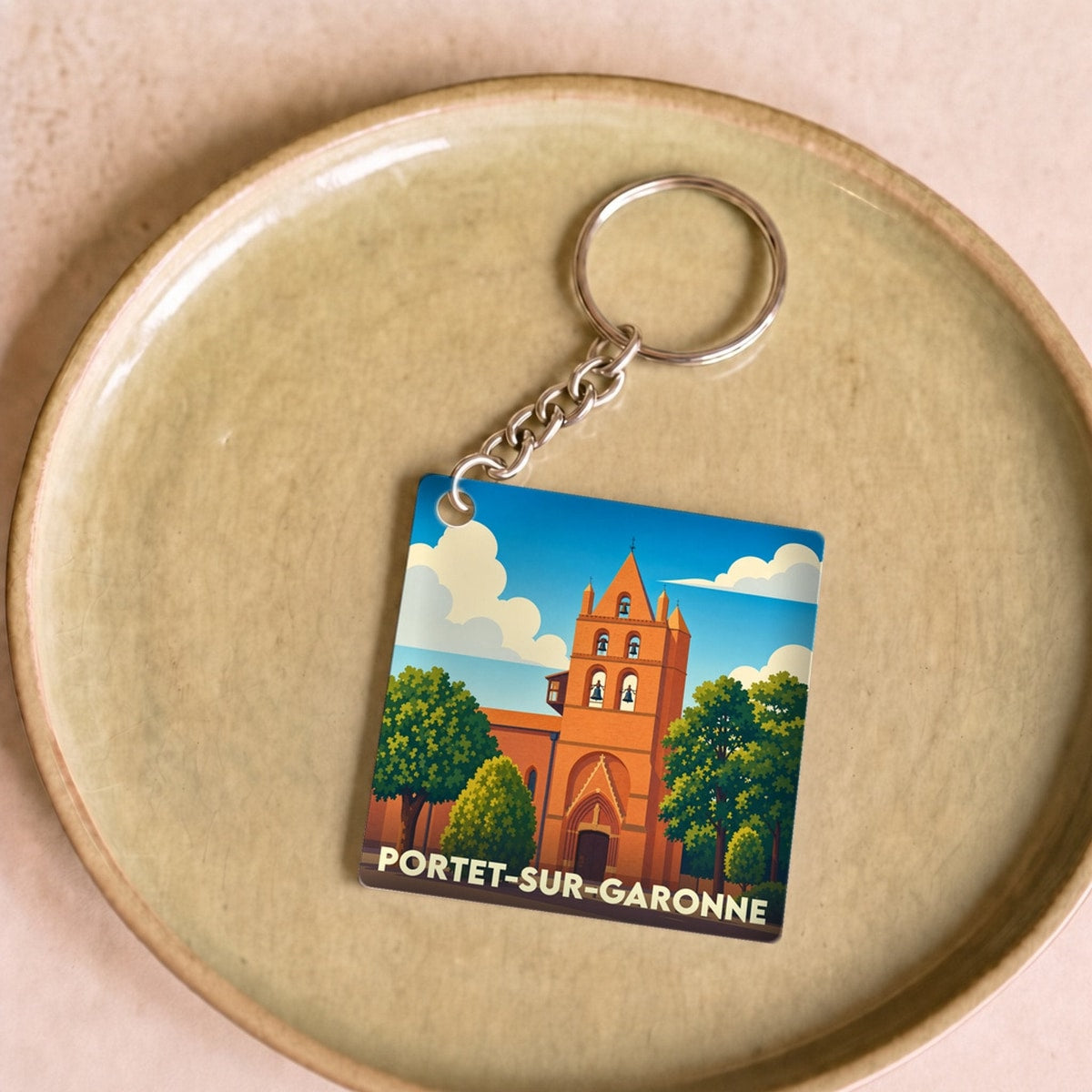 Porte-clés souvenir de la ville de Portet-sur-Garonne avec une illustration stylisée de son église.