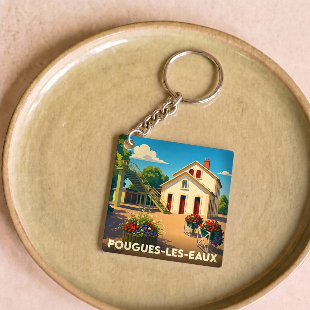 Porte-clés souvenir de la ville de Pougues-les-Eaux avec une illustration stylisée.