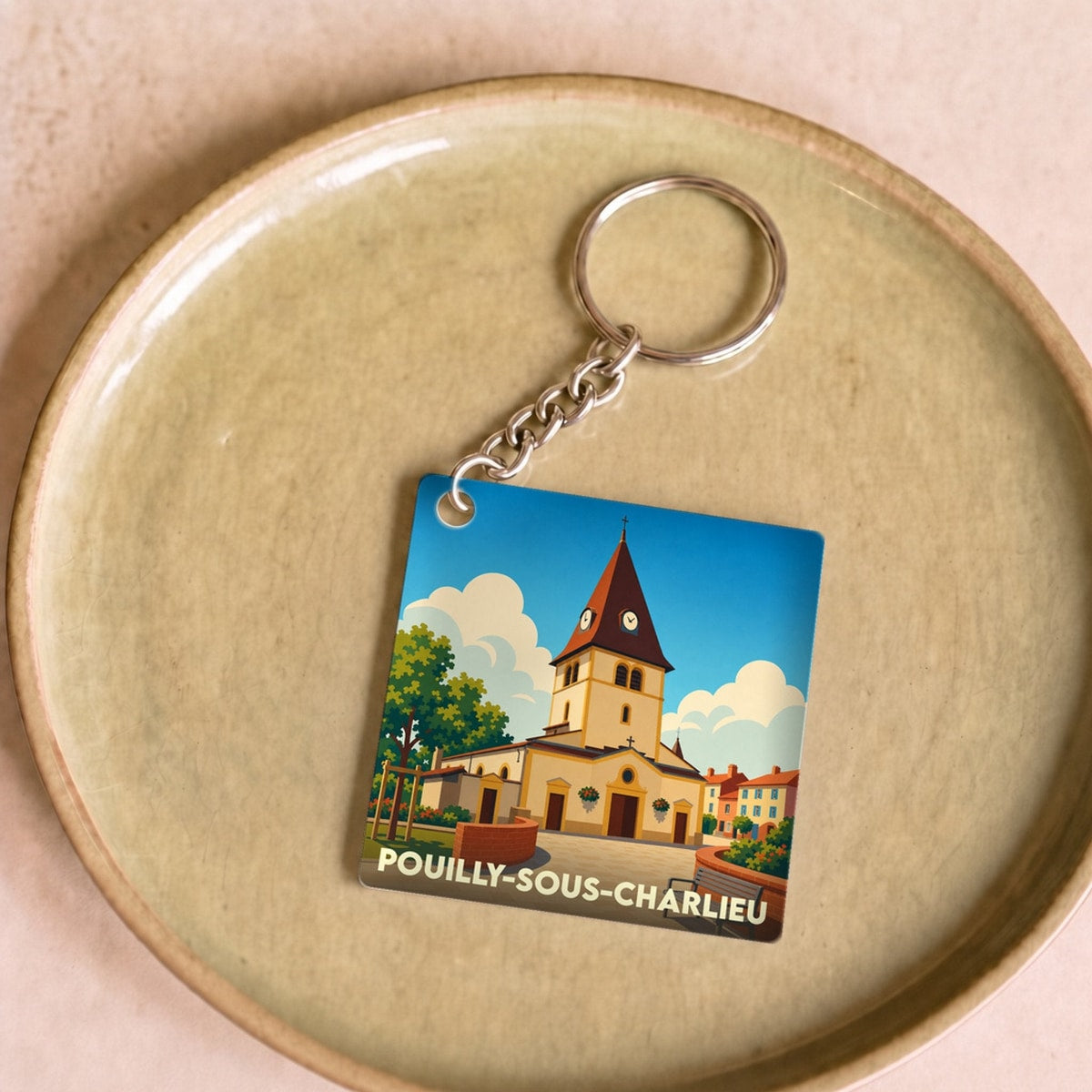 Porte-clés souvenir de la ville de Pouilly-sous-Charlieu avec une illustration stylisée de son église.