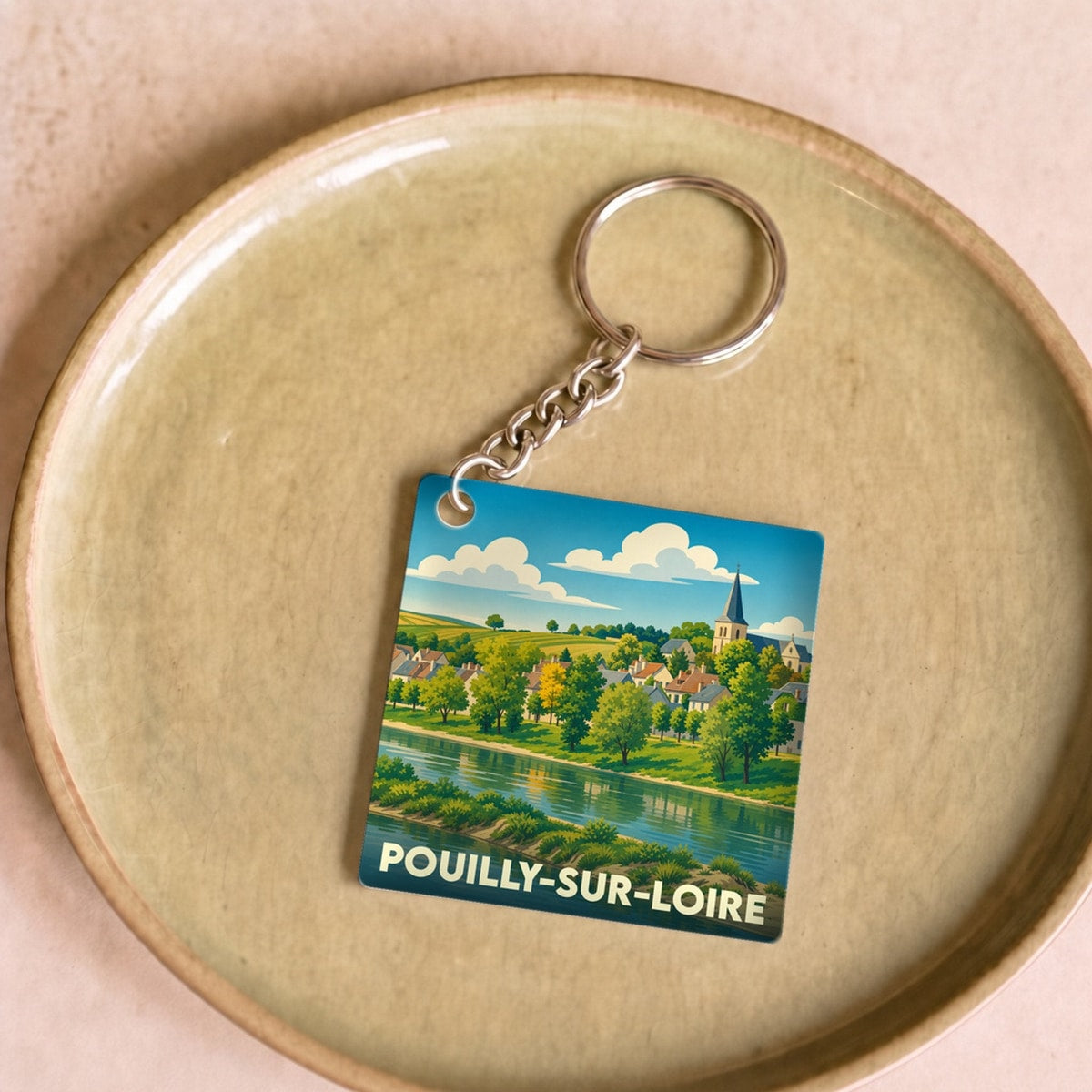 Porte-clés souvenir de la ville de Pouilly-sur-Loire avec une illustration stylisée des bords de Loire.
