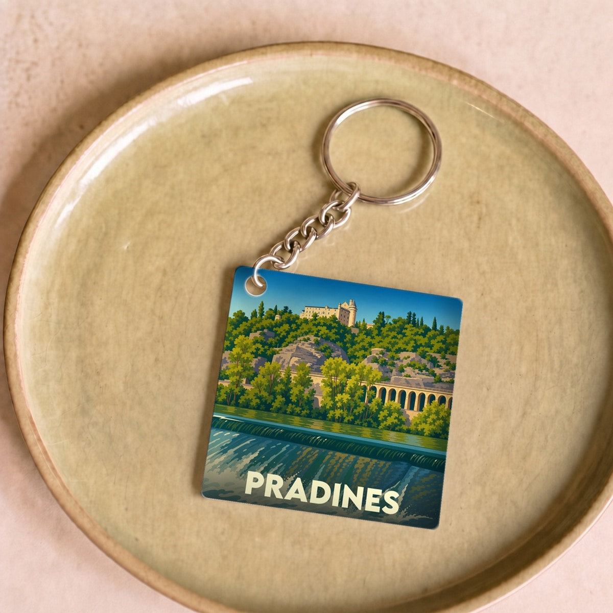 Porte-clés souvenir de la ville de Pradines avec une illustration stylisée d'un paysage fluvial.