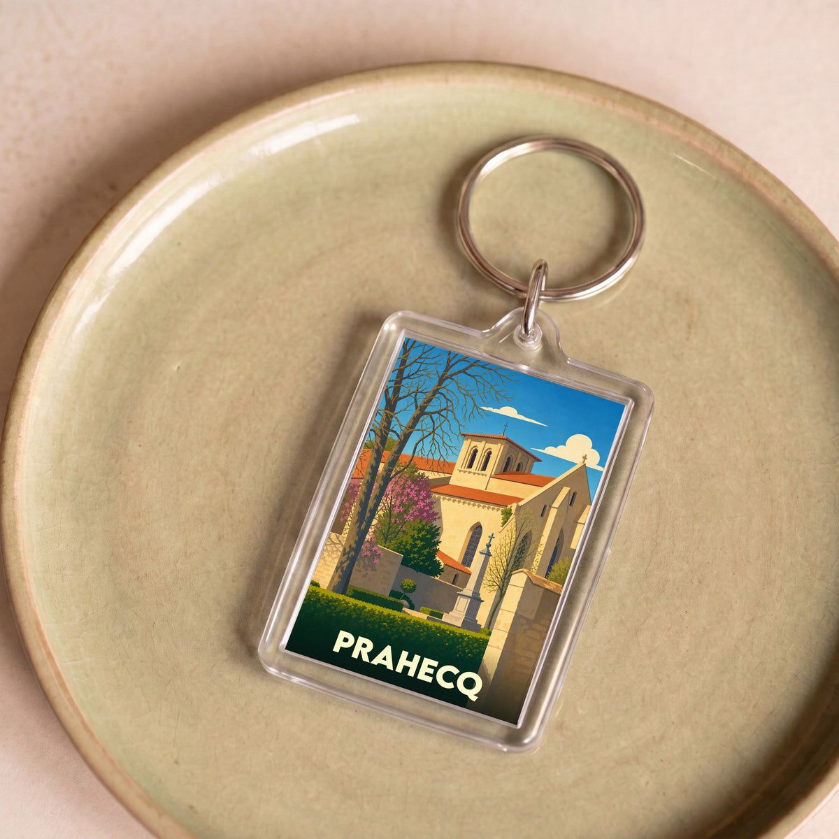 Porte-clés souvenir de la ville de Prahecq avec une illustration stylisée de son église.