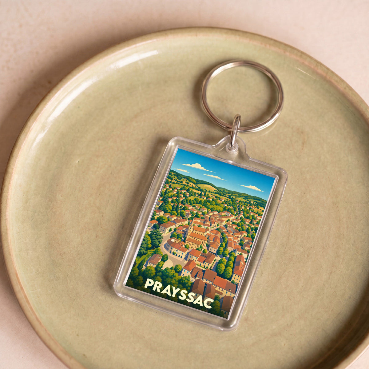 Porte-clés souvenir de la ville de Prayssac avec une illustration stylisée.