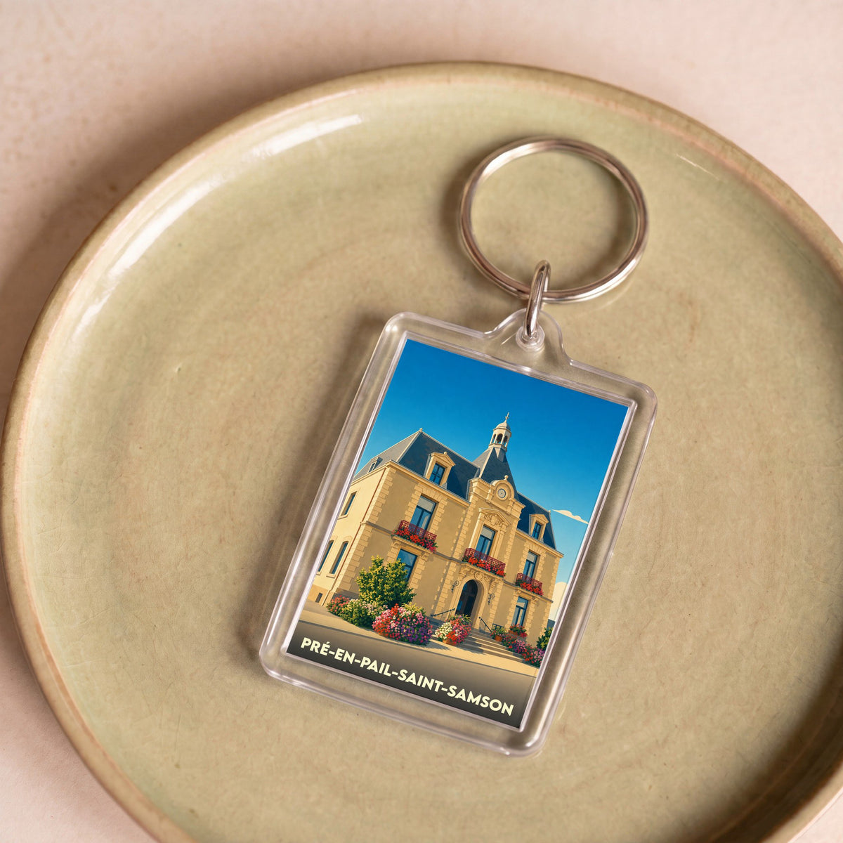 Porte-clés souvenir de la ville de Pré-en-Pail-Saint-Samson avec une illustration stylisée de son hôtel de ville.