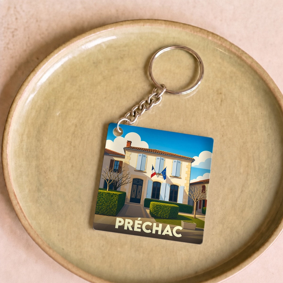Porte-clés souvenir de la ville de Préchac avec une illustration stylisée.
