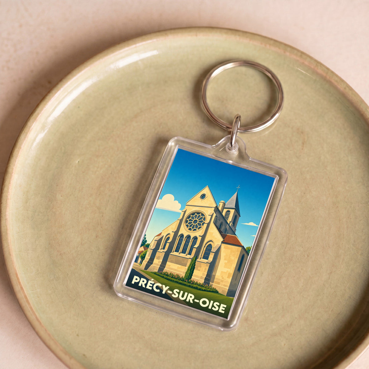 Porte-clés souvenir de la ville de Précy-sur-Oise avec une illustration stylisée de son église.