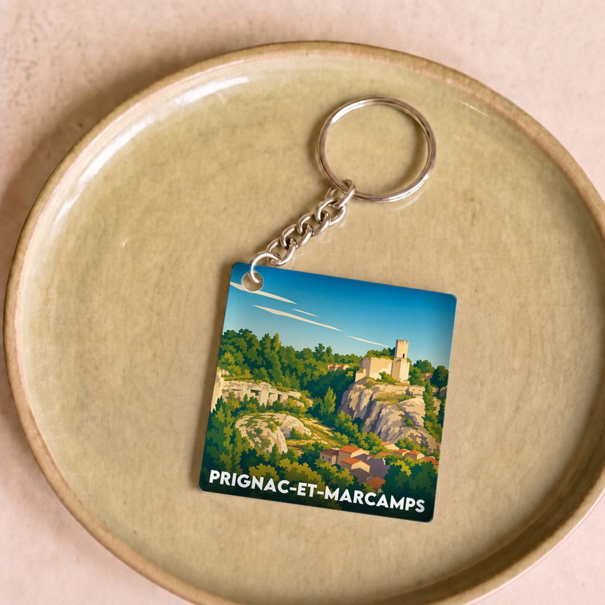 Porte-clés souvenir de la ville de Prignac-et-Marcamps avec une illustration stylisée.