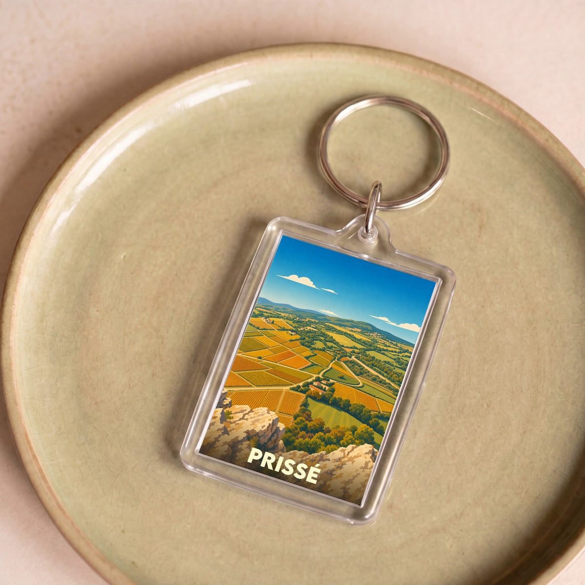Porte-clés souvenir de la ville de Prissé avec une illustration stylisée de ses paysages de vignes.