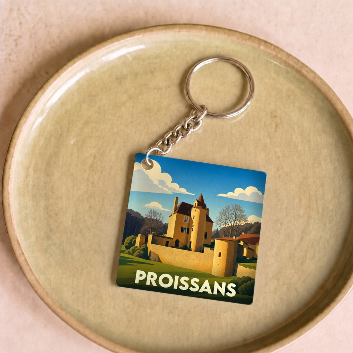 Porte-clés souvenir de la ville de Proissans avec une illustration stylisée de son château.