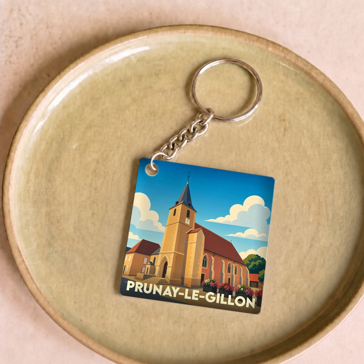 Porte-clés souvenir de la ville de Prunay-le-Gillon avec une illustration stylisée de son église.