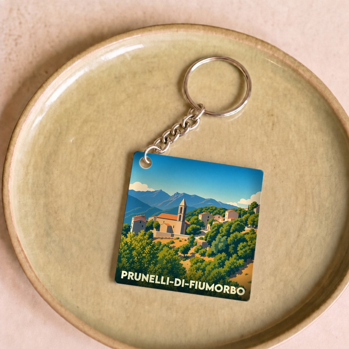 Porte-clés souvenir de la ville de Prunelli-di-Fiumorbo avec une illustration stylisée de son village.