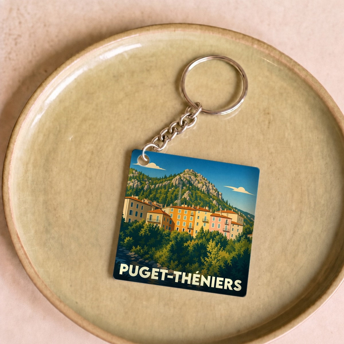 Porte-clés souvenir de la ville de Puget-Théniers avec une illustration stylisée.