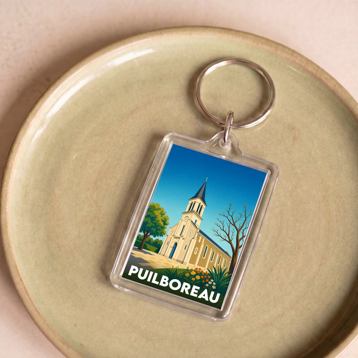 Porte-clés souvenir de la ville de Puilboreau avec une illustration stylisée de son église.