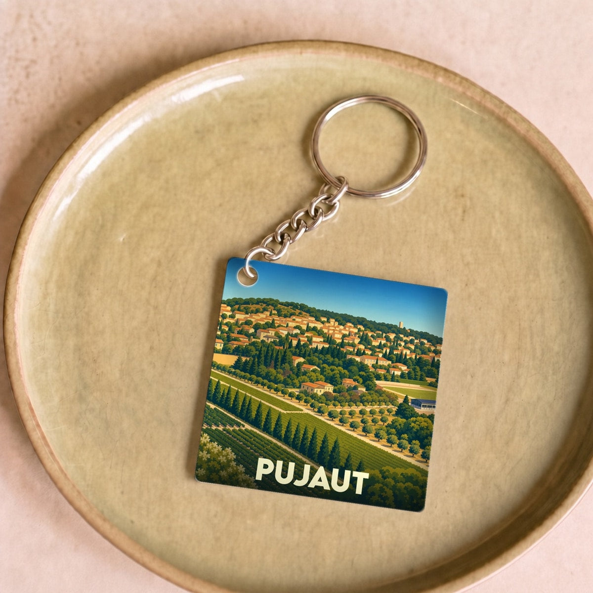 Porte-clés souvenir de la ville de Pujaut avec une illustration stylisée de son paysage vallonné.