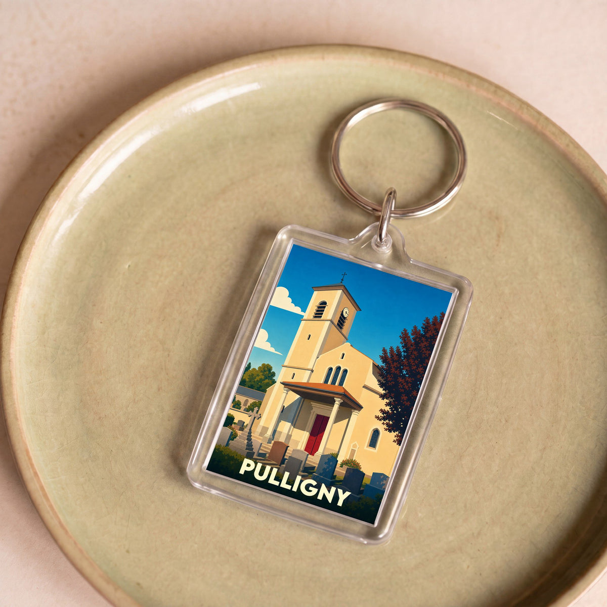 Porte-clés souvenir de la ville de Pulligny avec une illustration stylisée de son église.