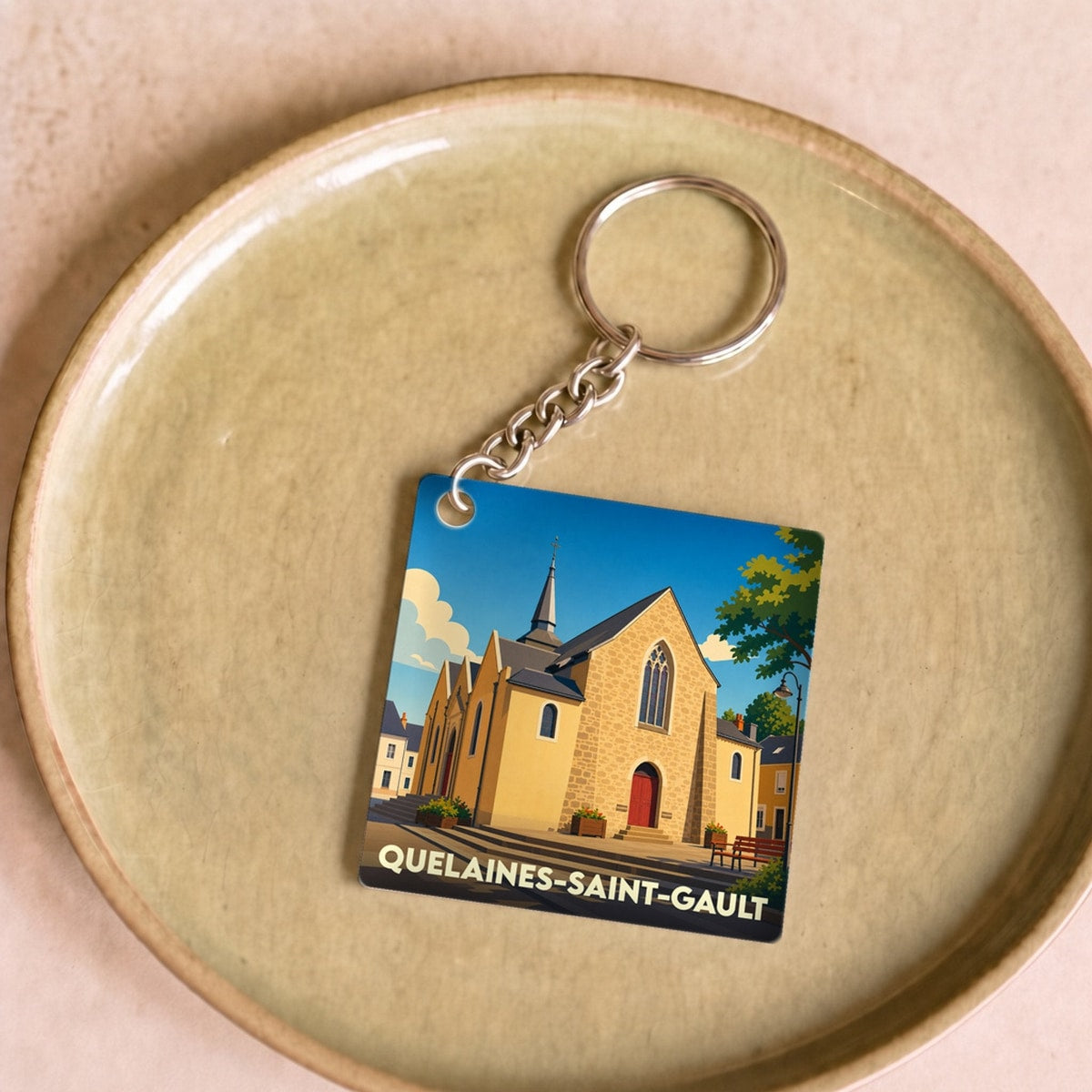 Porte-clés souvenir de la ville de Quelaines-Saint-Gault avec une illustration stylisée de son église.