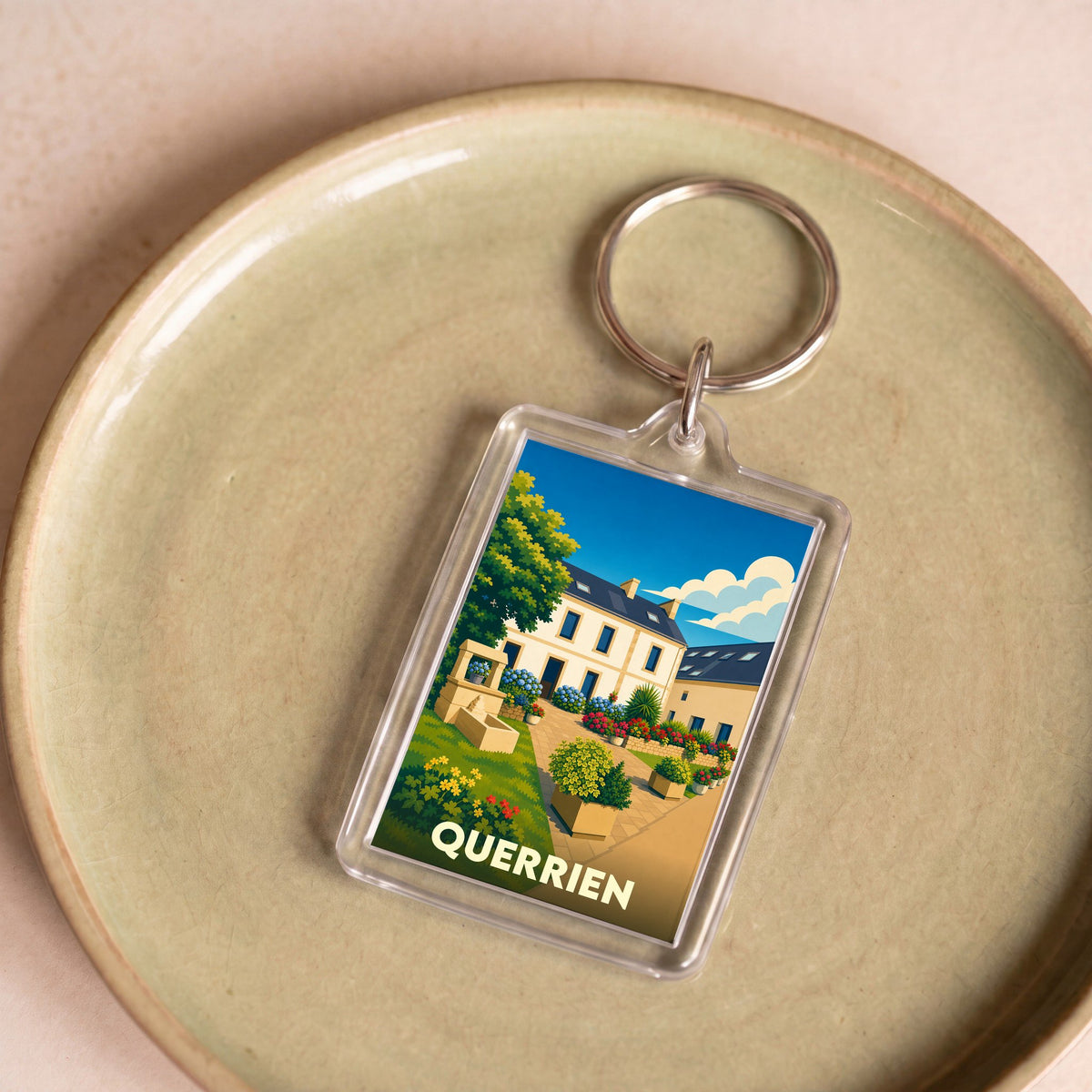 Porte-clés souvenir de la ville de Querrien avec une illustration colorée et stylisée.