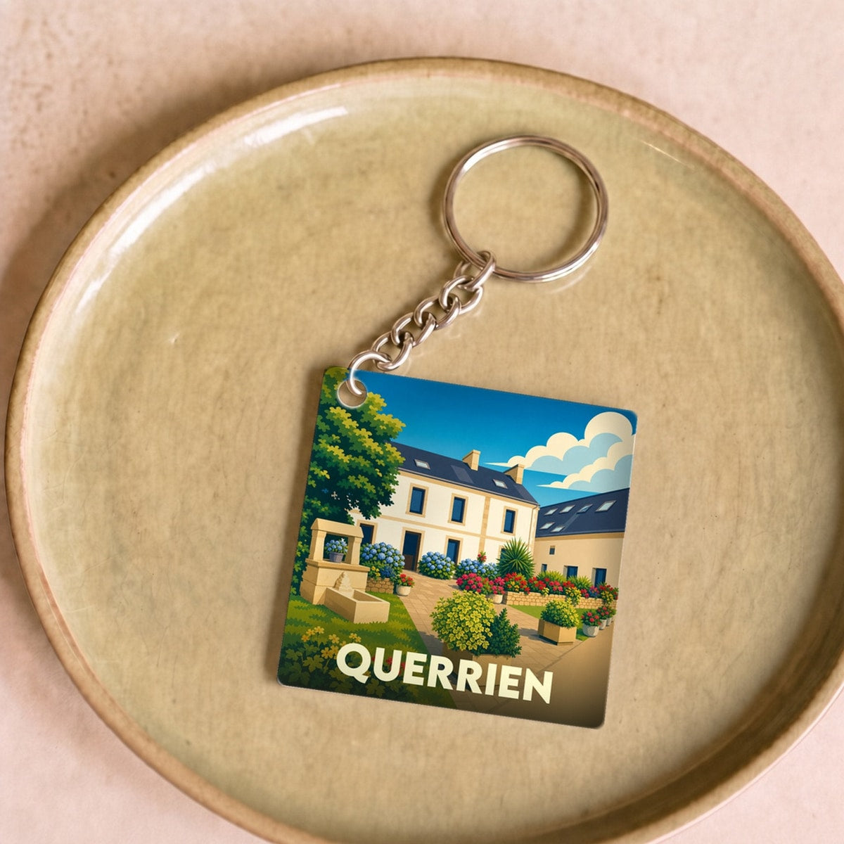 Porte-clés souvenir de la ville de Querrien avec une illustration colorée et stylisée.