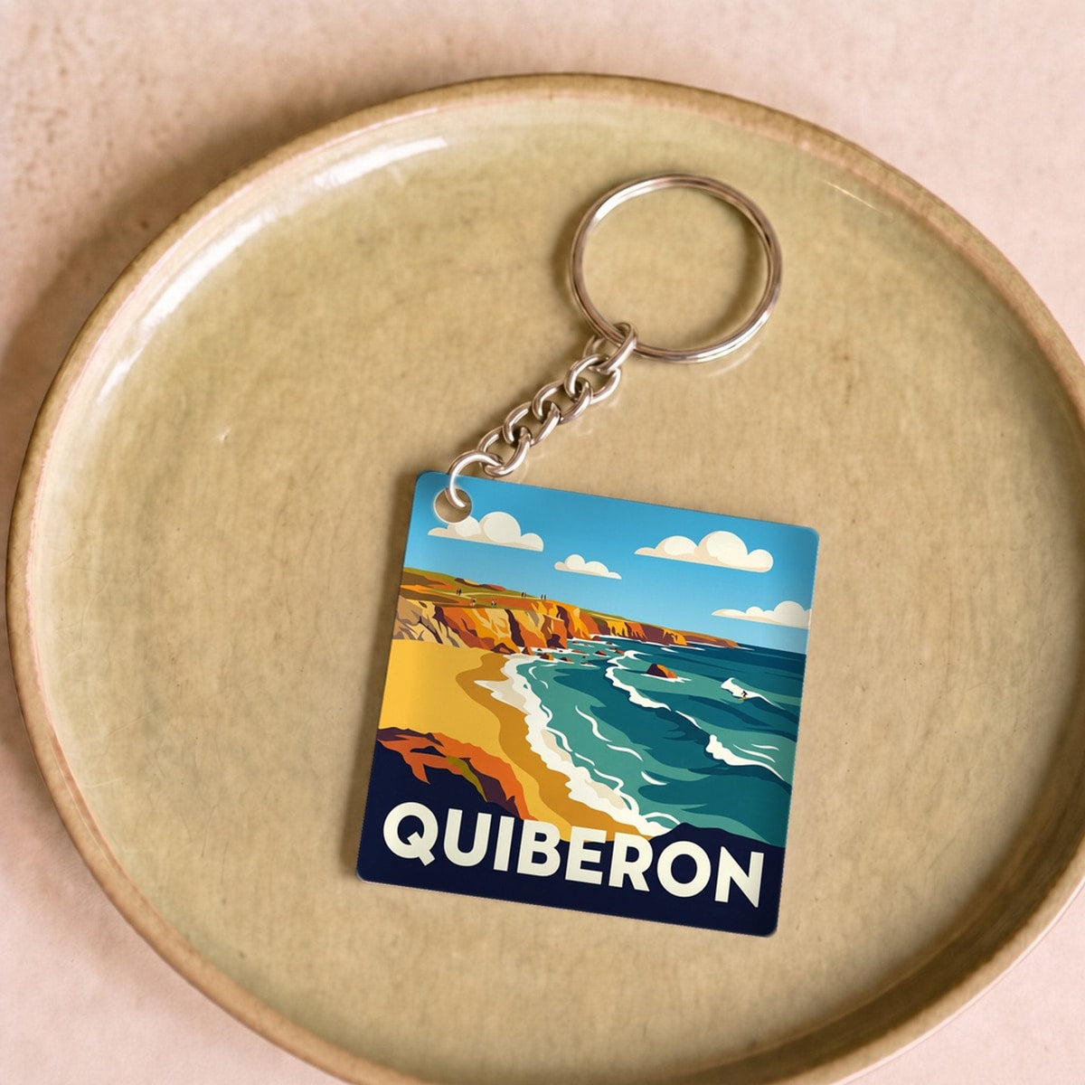 Porte-clés souvenir de la ville de Quiberon avec une illustration stylisée de son littoral.