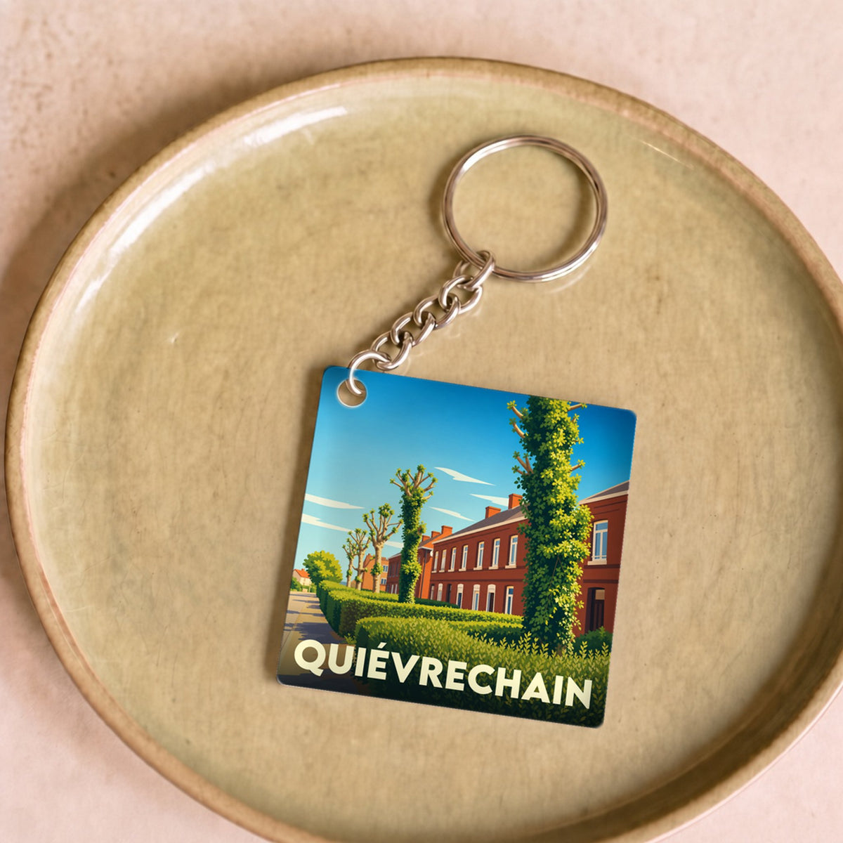 Porte-clés souvenir de la ville de Quiévrechain avec une illustration stylisée.