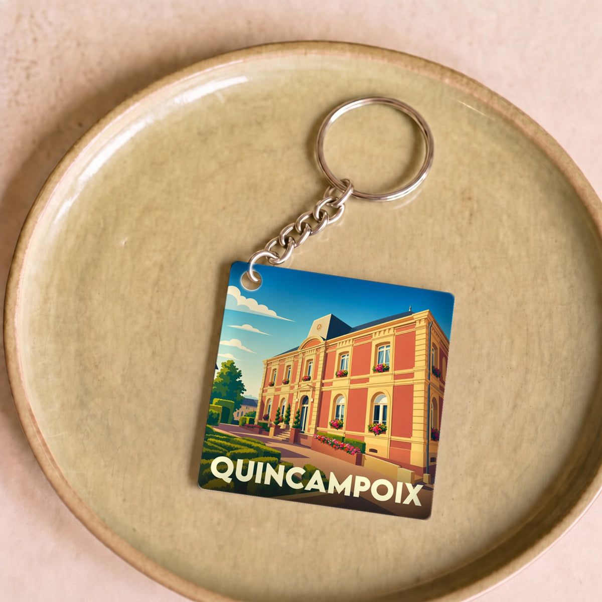Porte-clés souvenir de la ville de Quincampoix avec une illustration stylisée.