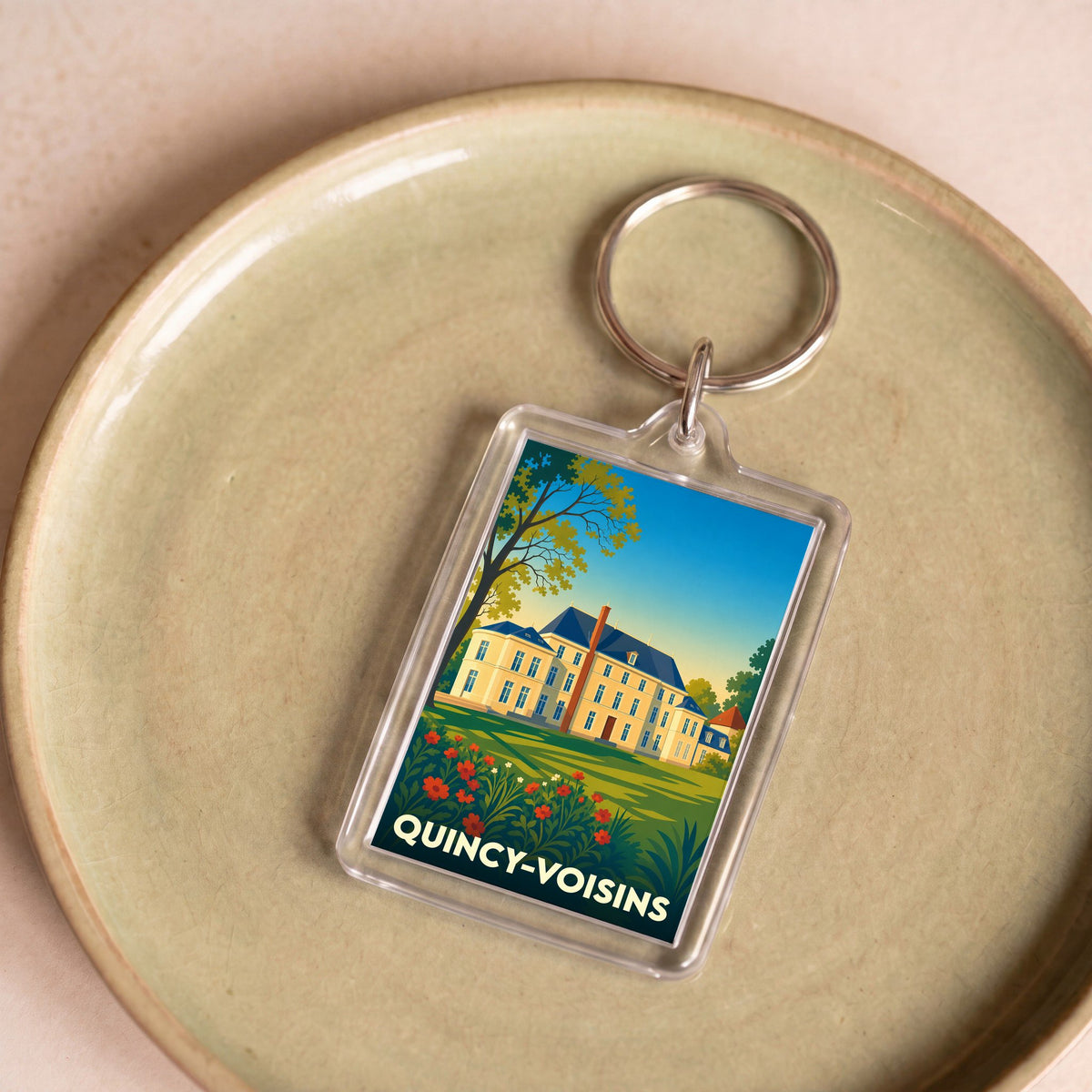 Porte-clés souvenir de la ville de Quincy-Voisins avec une illustration stylisée d'un château.