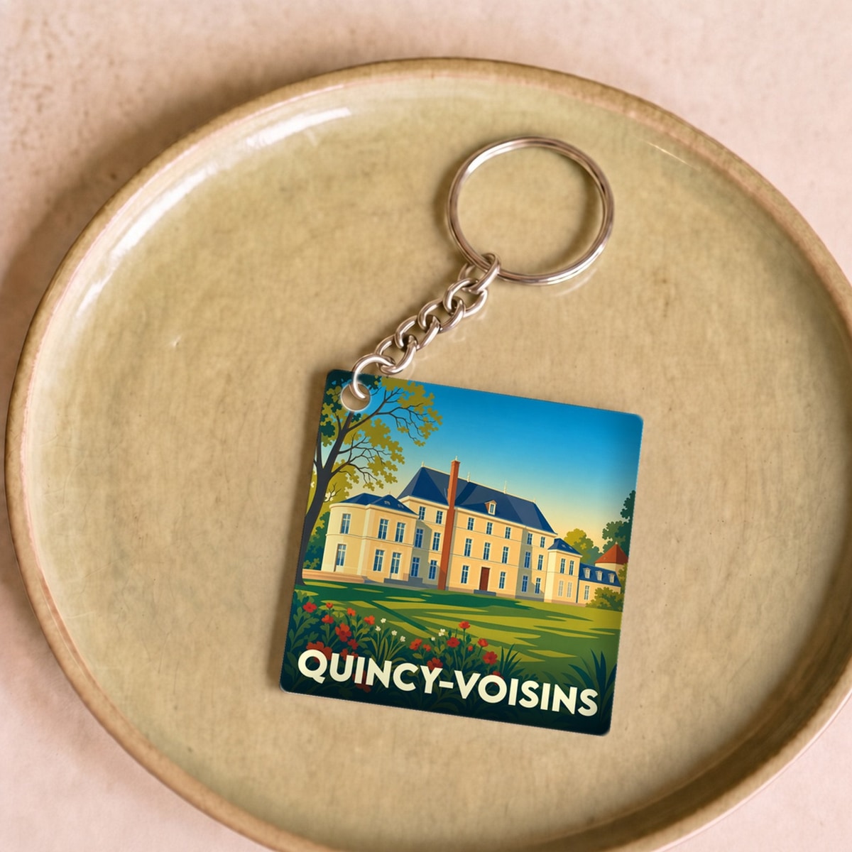 Porte-clés souvenir de la ville de Quincy-Voisins avec une illustration stylisée de son château.