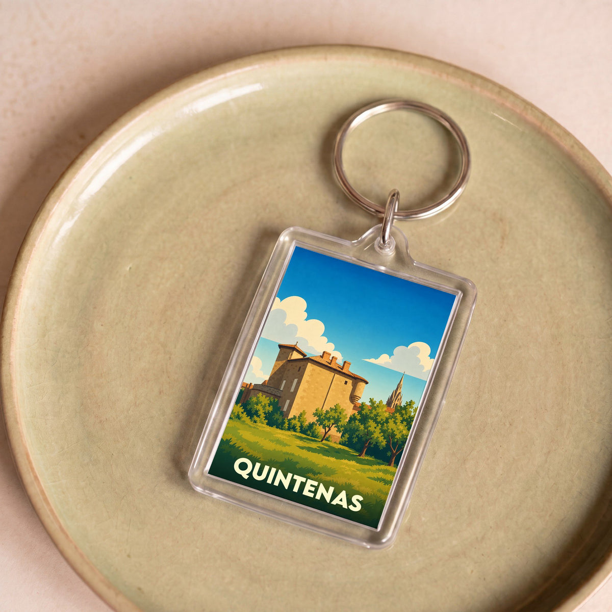Porte-clés souvenir de la ville de Quintenas avec une illustration stylisée d'un château.