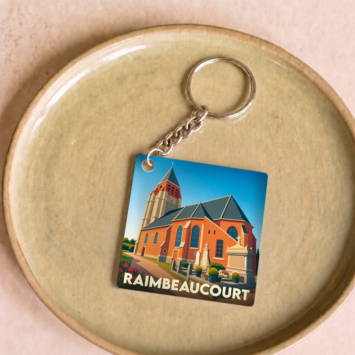 Porte-clés souvenir de la ville de Raimbeaucourt avec une illustration stylisée de son église.