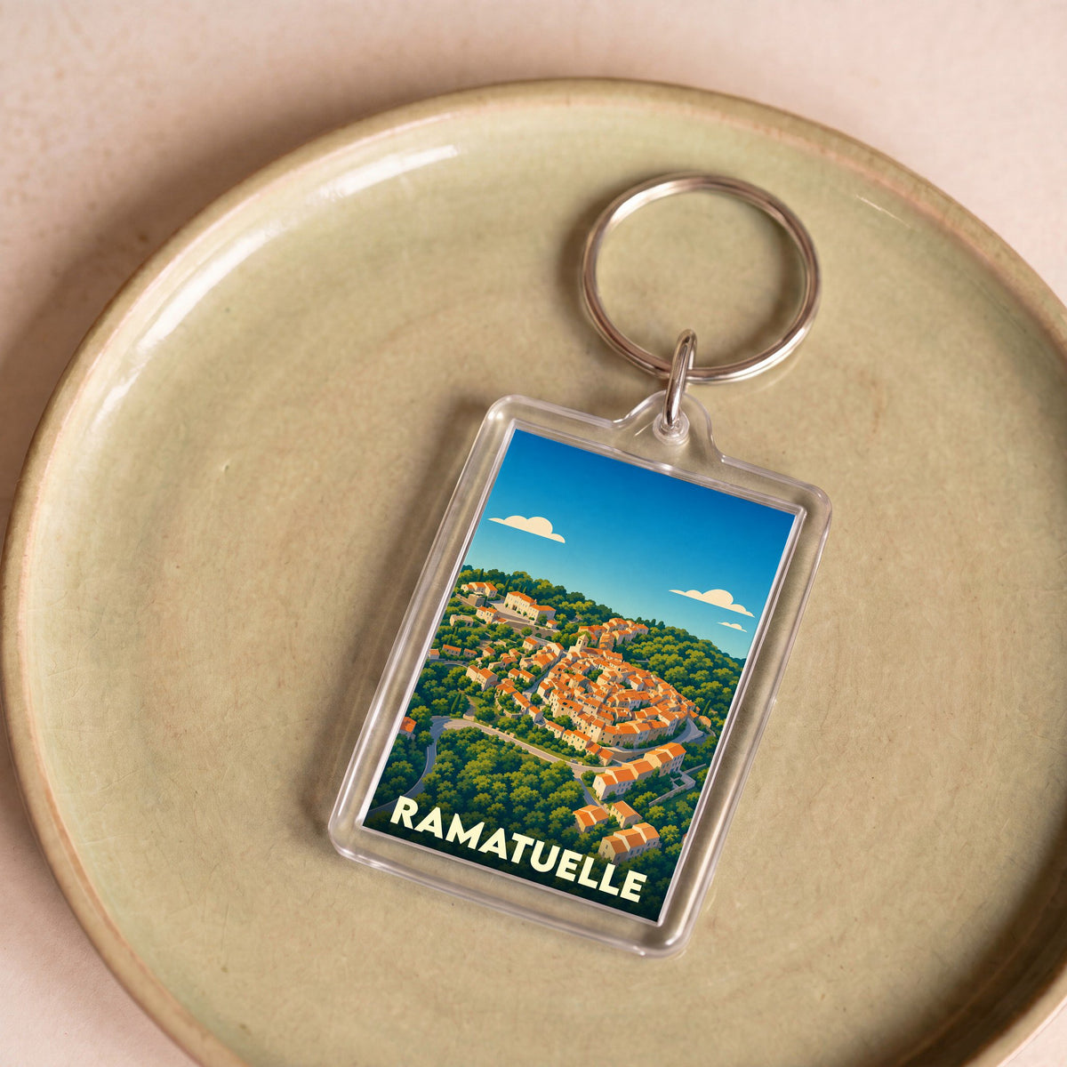 Porte-clés souvenir de la ville de Ramatuelle avec une illustration stylisée.