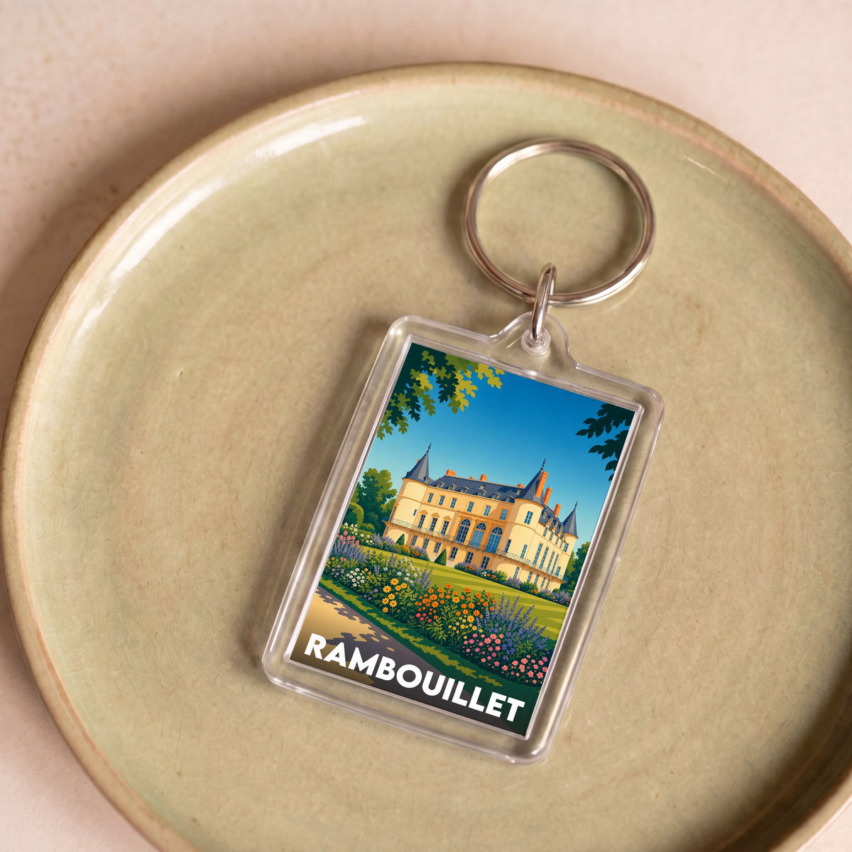 Porte-clés souvenir de la ville de Rambouillet avec une illustration stylisée du château.