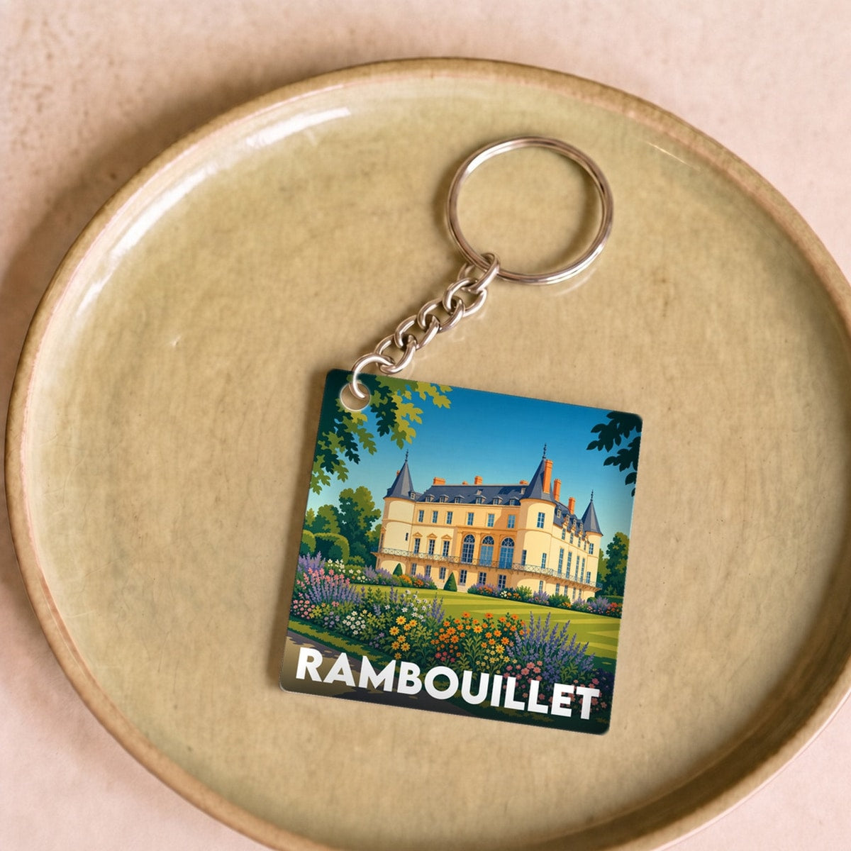 Porte-clés souvenir de la ville de Rambouillet avec une illustration stylisée du château.