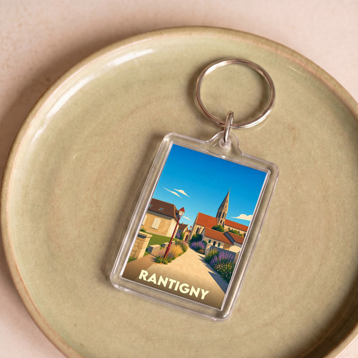 Porte-clés souvenir de la ville de Rantigny avec une illustration stylisée d'un paysage urbain.