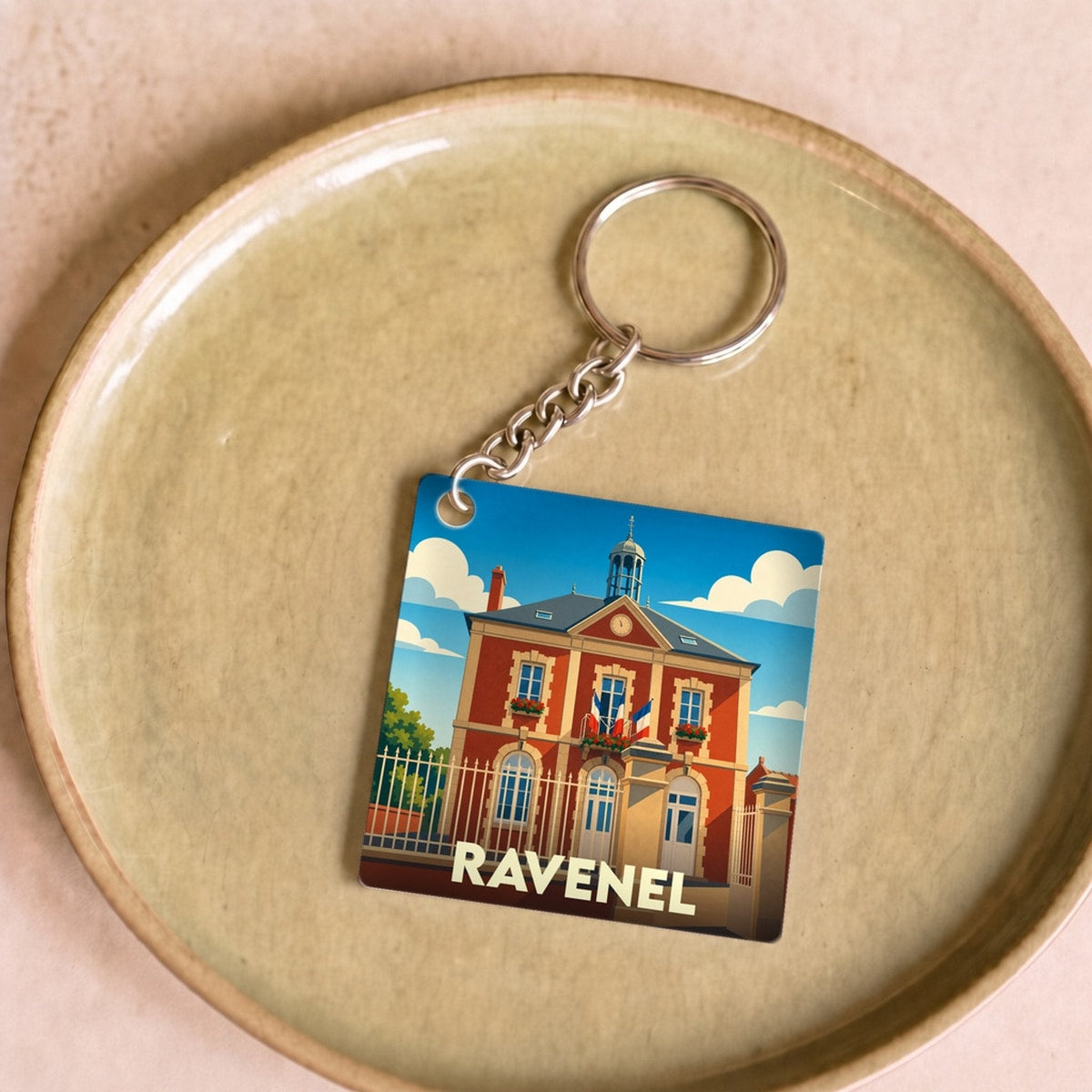 Porte-clés souvenir de la ville de Ravenel avec une illustration stylisée de sa mairie.